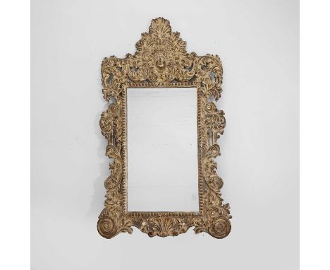 A large gilt wall mirror, of recent manufacture, composite, the pierced scrolling crest surmounted by a shell over a cherub m