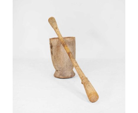 A large hardwood mortar and pestle, 19th/20th century, possibly Burkina Faso, with a distressed finish, raised on a circular 