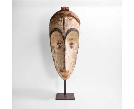 A painted mask 20th century, Gabon, Fang people, the elongated nose leading to raised, arched brows, with narrow cut-out eyes