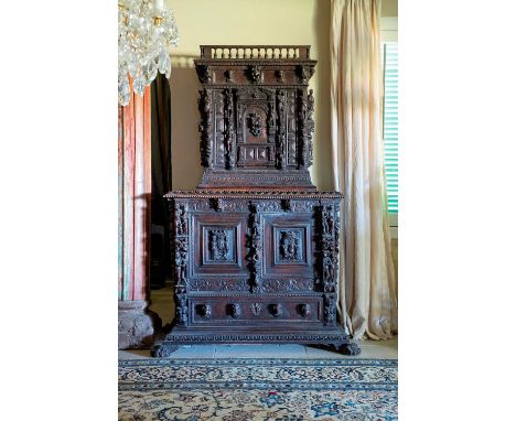 A carved walnut 'a bambocci' cabinet, c.1560, North Italian, Bologna, the upper section, seemingly original, with a balustrad