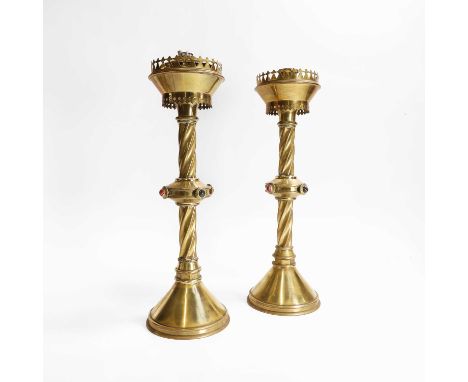 A pair of Gothic Revival brass altar candlesticks, 19th century, each with a pierced gallery over a spiralled and cabochon-in