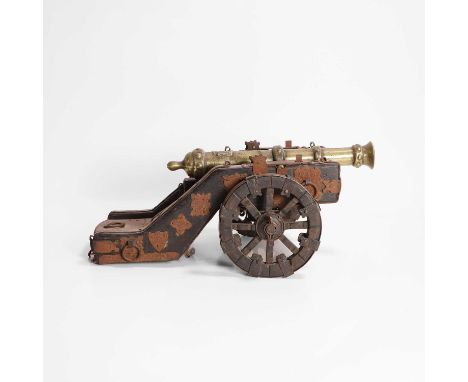 A miniature brass model of a cannon, 20th century, cast with a coat of arms, and mounted on a carriage, 34cm wide19cm deep14.