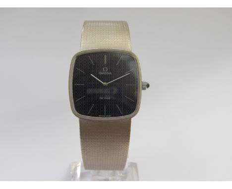 OMEGA: a De Ville 18ct gold manual wind gent's bracelet watch, blue patterned dial with white hands and markers, cabochon sap