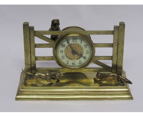 An early 20th Century brass novelty timepiece in the form of two dogs chasing a fox near a gate, French single train drum mov