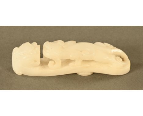 A Chinese white jade button hook, carved with a Chilong.  Length 8.5 cm.