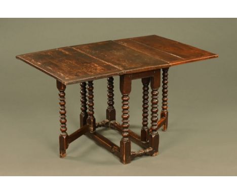A 17th century oak gate leg table with bobbin turned legs.  Height 74.5 cm, width 86 cm, length flaps up 130 cm. CONDITION RE