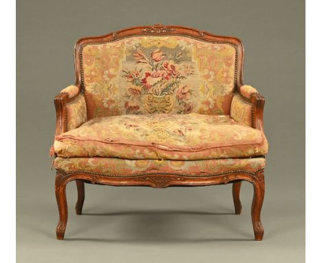 A late 19th century French beechwood fauteuil, upholstered in foliate tapestry material.  Height 90 cm, width across arms 94 