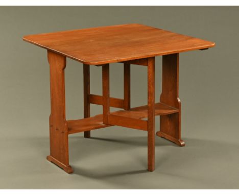 An Arts &amp; Crafts oak gate legged dining table, each flap with rounded corners and each end of silhouette outline.  Height