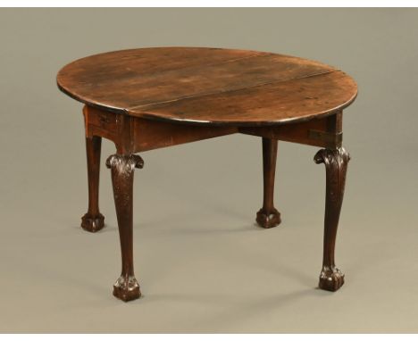 A George II mahogany gate leg table, raised on boldly carved cabriole legs and claw and ball feet.  The oval top above a frie