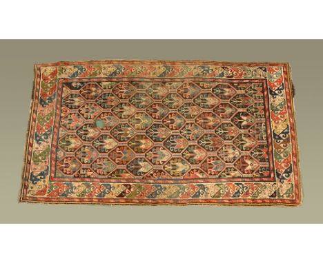 An Eastern fringed carpet, with rectangular centre panel with repeating diamond shaped design and with multiple line border, 