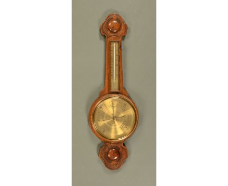 A carved oak aneroid barometer, circa 1930 and with mercury thermometer.  Height 79 cm.