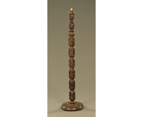 A carved wooden lamp standard, all over carved with birds and flower heads.