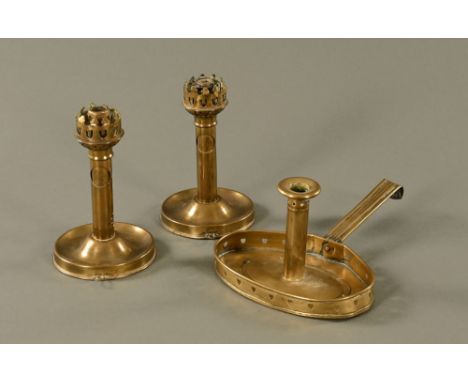 An Arts &amp; Crafts brass chamber stick, together with a pair of ships candlesticks.  Tallest 20 cm.