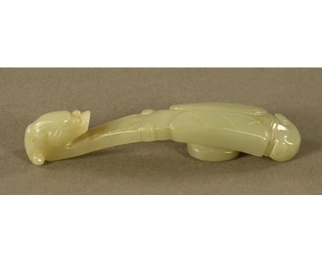 A Chinese carved jade button or belt hook in the form of a Chilong with folded wings.  Length 11 cm.