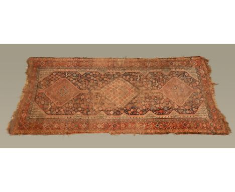 An antique Persian carpet, rectangular, the centre panel with three diamond motifs with bird, animal and repeating decoration