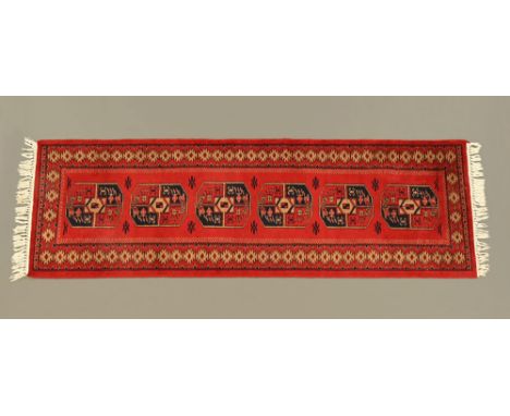 A Persian style fringed runner, with six similar designs to the centre rectangular panel and with multiple line border, princ