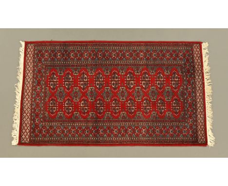 A Bokhara rug, rectangular with fringed ends, the centre rectangular panel with repeating elephant foot design and with multi