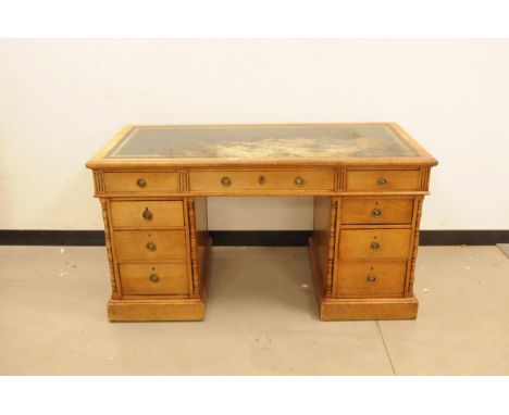 An early 20th century light wood pedastal desk, 128cm wide, with stained leatherette top and some other damages 