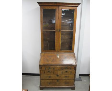 A Georgian figured walnut veneered bureau bookcase, upper section with moulded cornice, two glass panelled doors fitted with 