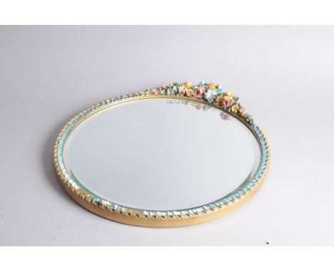 A c1960s ceramic framed mirror, 39cm diameter, with floral decoration and garland to top 