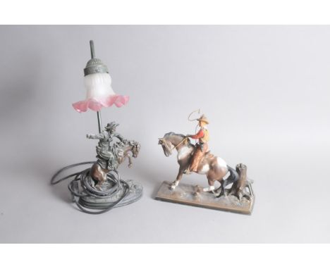 Two vintage cowboy related decorative items, including a cowboy on horseback matchstrike, 26cm, and a figural lamp base, 42cm