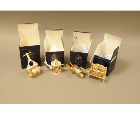 Four modern Royal Crown Derby porcelain garden related items, with boxes, including a garden roller, bench, watering can and 