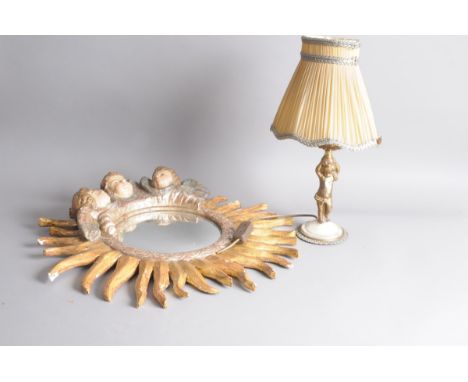 A modern plaster sun burst mirror, 62cm, with three chreub heads, damaged, together with an early 20th century spelter cherub