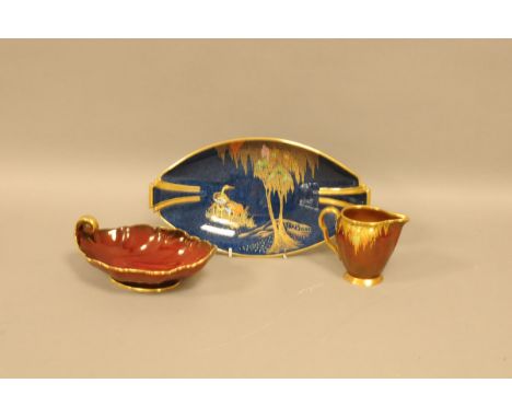 Three items of Carltonware pottery, including a blue ground oval dish, 27.5cm, a red ground jug and leaf dish (3) 