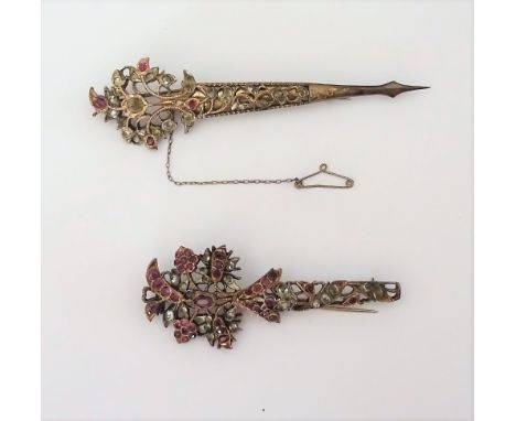 Two Indian ruby and jargoon set turban pins, each with pierced floral decoration, (2).