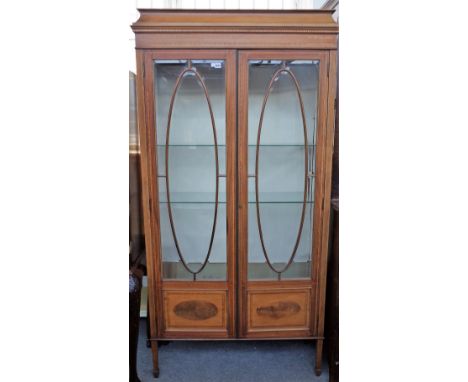 An Edwardian kingwood inlaid mahogany display cabinet, the caddy top over a pair of bevelled glass astragal doors, on taperin