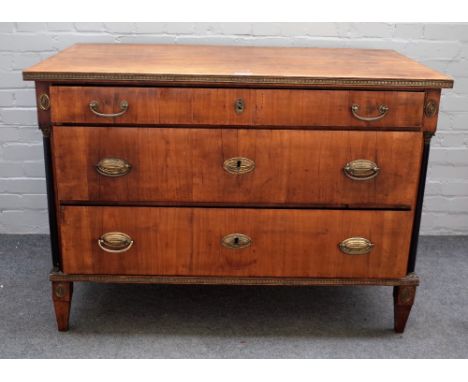 An 18th century French gilt metal mounted walnut commode, with three long graduated drawers flanked by ebonised columns, on t