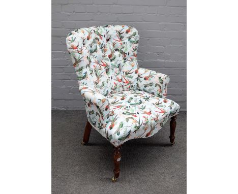 A Victorian style button back easy armchair with Bird of Paradise upholstery, on turned supports, 69cm wide x 96cm high. 