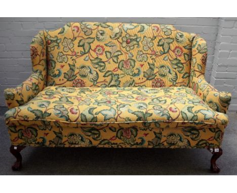 A George II style stained beech floral upholstered wingback sofa, on claw and ball feet, 165cm wide x 102cm high. 