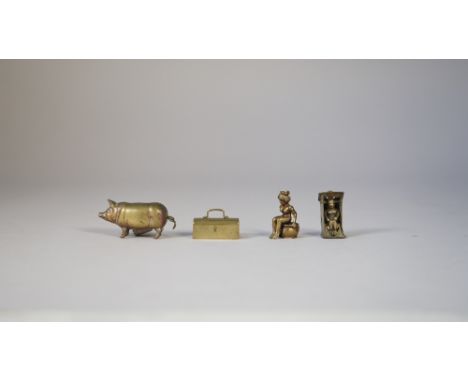 A novelty brass cigar cutter, early 20th century, modelled as a naked woman, seated on a chamber pot (3cm), another similar m