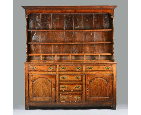 A George III mahogany banded oak dresser, the enclosed three tier shelf back with six spice drawers, the base with six short 