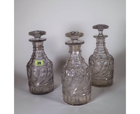 A set of three Regency cut glass decanters and stoppers, early 19th century, each cylindrical body cut with a band of gadroon