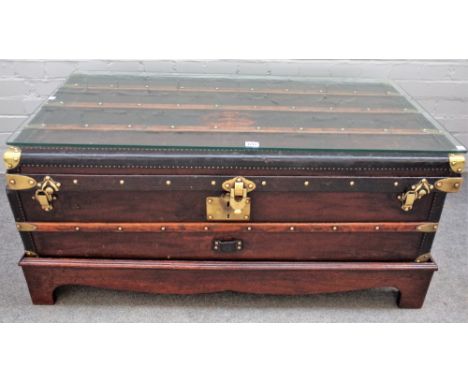 A leather and brass bound steamer trunk/ coffee table, on later stand, 110cm wide x 52cm high. 