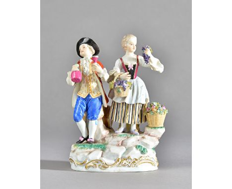 A Meissen group of vintners, circa 1900, modelled as a youth and companion standing on a rocky mound base, he holding a flask