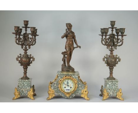A three-piece French marble and spelter clock surmounted by a female figure titled 'Le Bouton D'Oro', foliate painted enamel 