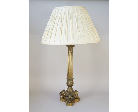 An Ormolu table lamp of fluted column form raised on three lion paw feet and a triform shaped base with pleated cream silk sh