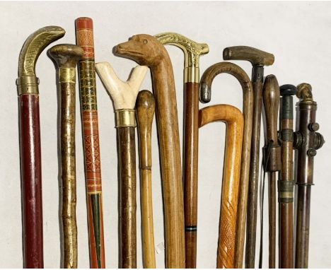 A selection of various walking sticks etc including a brass handled collapsible stick with concealed flask, a duck handled st