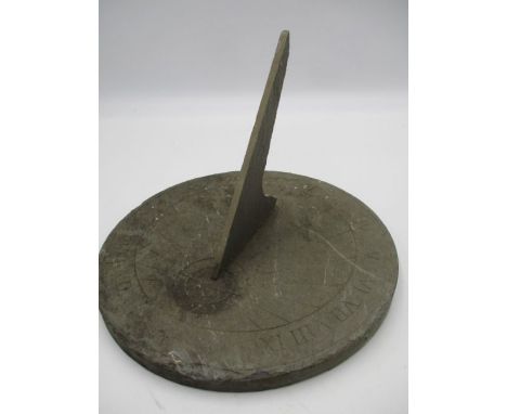 A circular slate sundial with Roman numerals, diameter 24.5cm