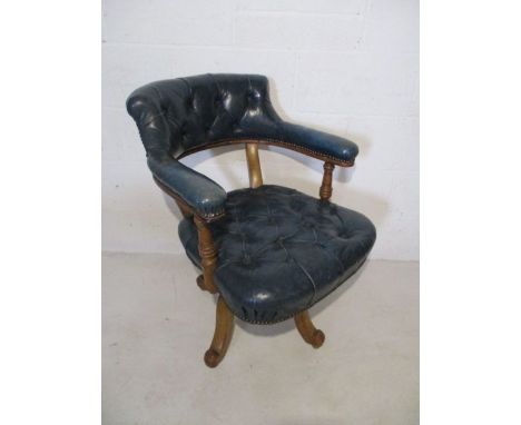 An Edwardian office chair with faded blue leather button back seat and back rest