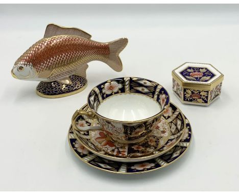 A small collection of Royal Crown Derby including an Imari pattern trio and trinket box along with a paperweight in the form 