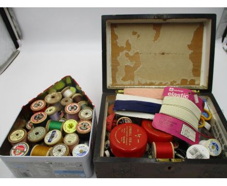 An assortment of vintage cotton reels and sewing accessories. In one wooden box and one tin.