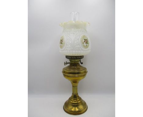 A vintage brass oil lamp with embossed glass shade
