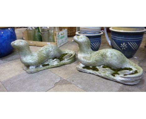 A pair of concrete otter garden figures 