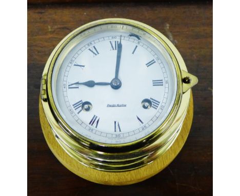 A brass cased ships clock having Roman numerals to the silvered dial 