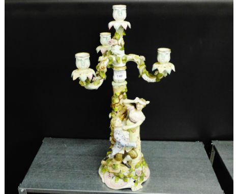 A continental porcelain figural table lamp base with detachable three-branch candelabra, all floral encrusted on a Rococo sty