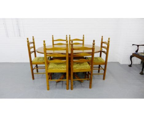 A pine drop leaf breakfast table together with a set of six ladder back and rush seat chairs (7)